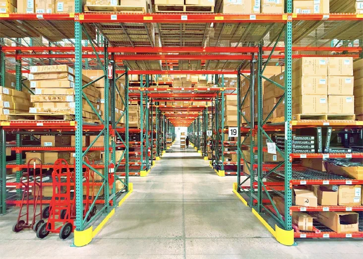 A large warehouse interior with neatly organized rows of shelving and storage bins