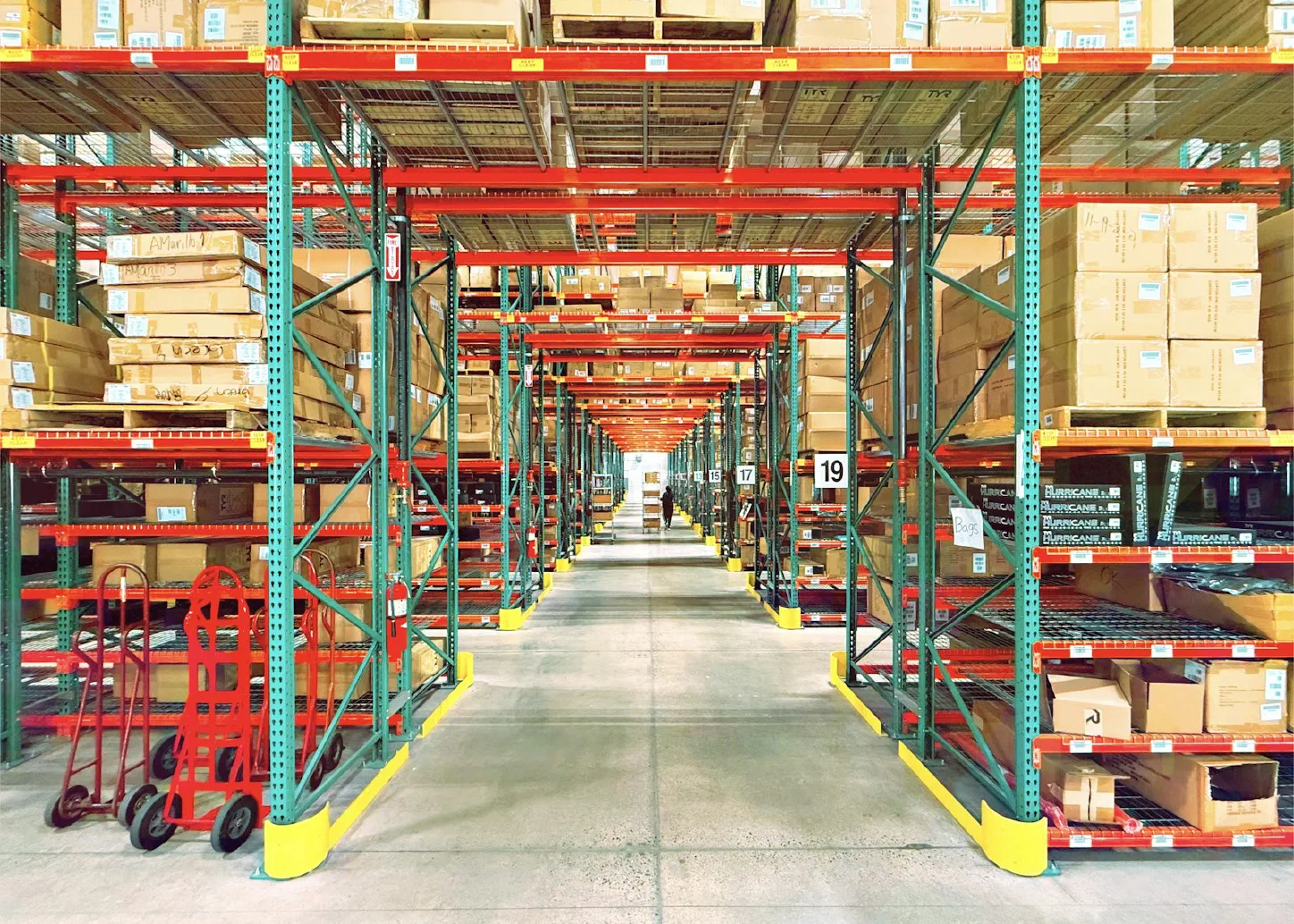 A large warehouse interior with neatly organized rows of shelving and storage bins
