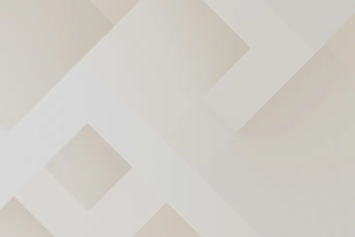 Abstract minimalist composition of overlapping cream and beige geometric planes forming diagonal, arrow-like shapes