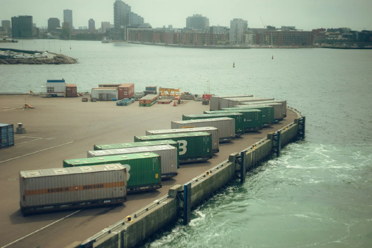 Shipping containers stacked and lined up at a busy port