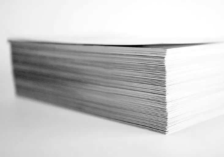 A neatly organized stack of printed paper sheets