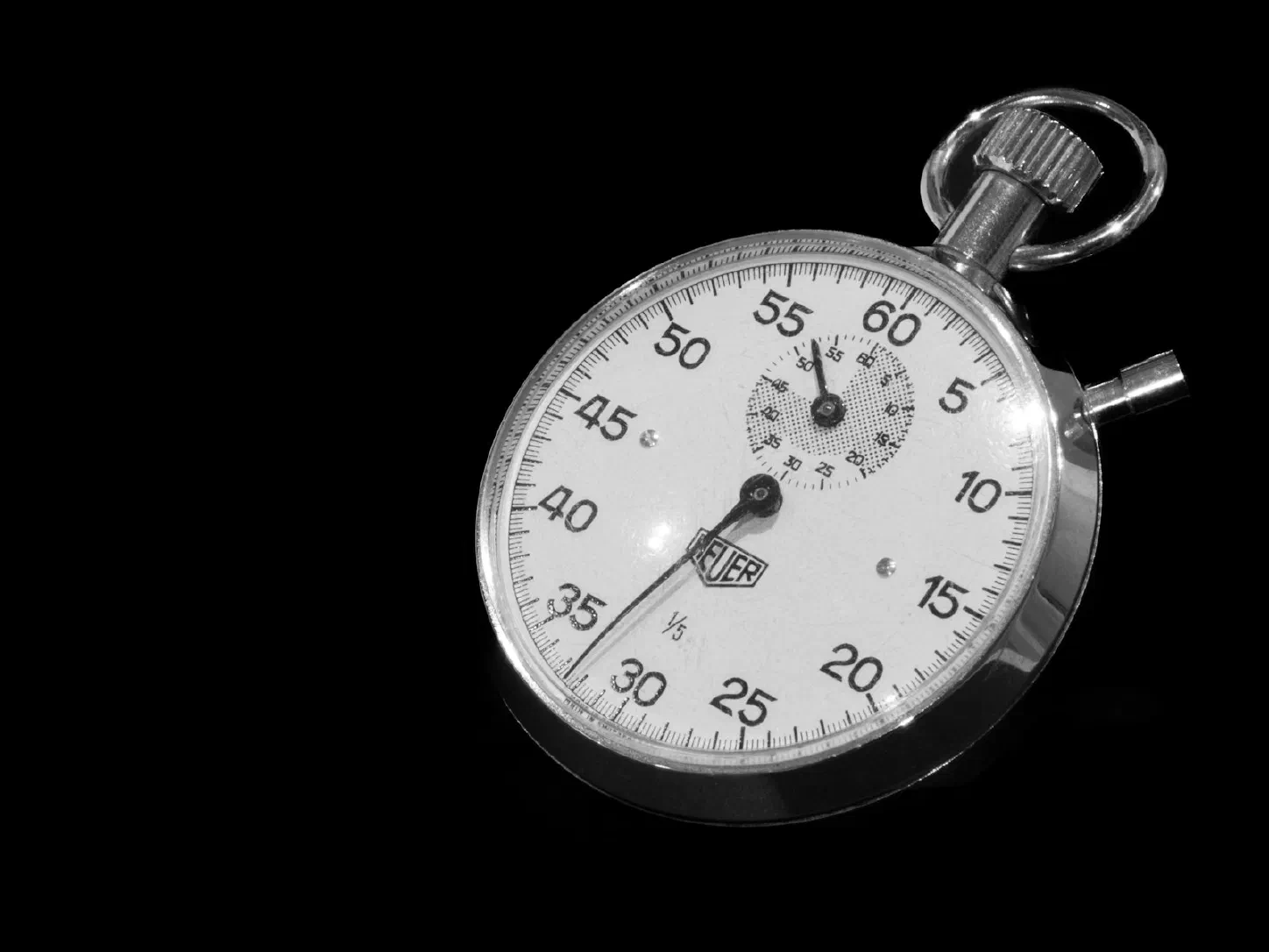 Close-up of a stopwatch face against a dark background