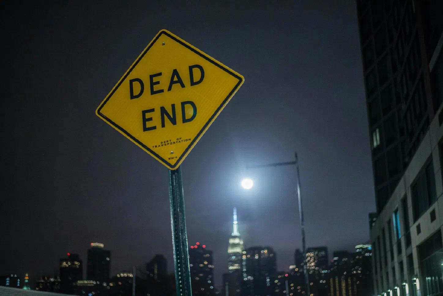 A yellow dead end road sign